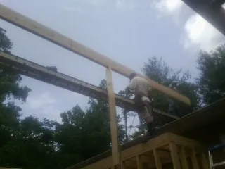 Carpenter setting a ridge beam over a new addition frame — Ice Dam Removal by Roofing Brothers in Natural Bridge Station