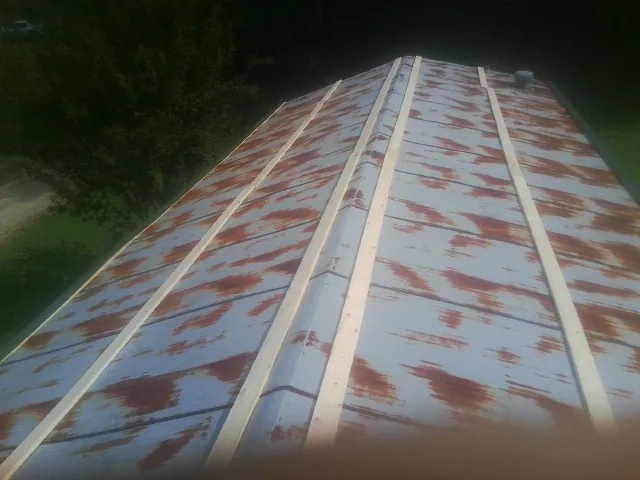 Rusted metal roof panels with new wood purlins before replacement — Storm Damage Roof Repair in Natural Bridge Station by Roofing Brothers