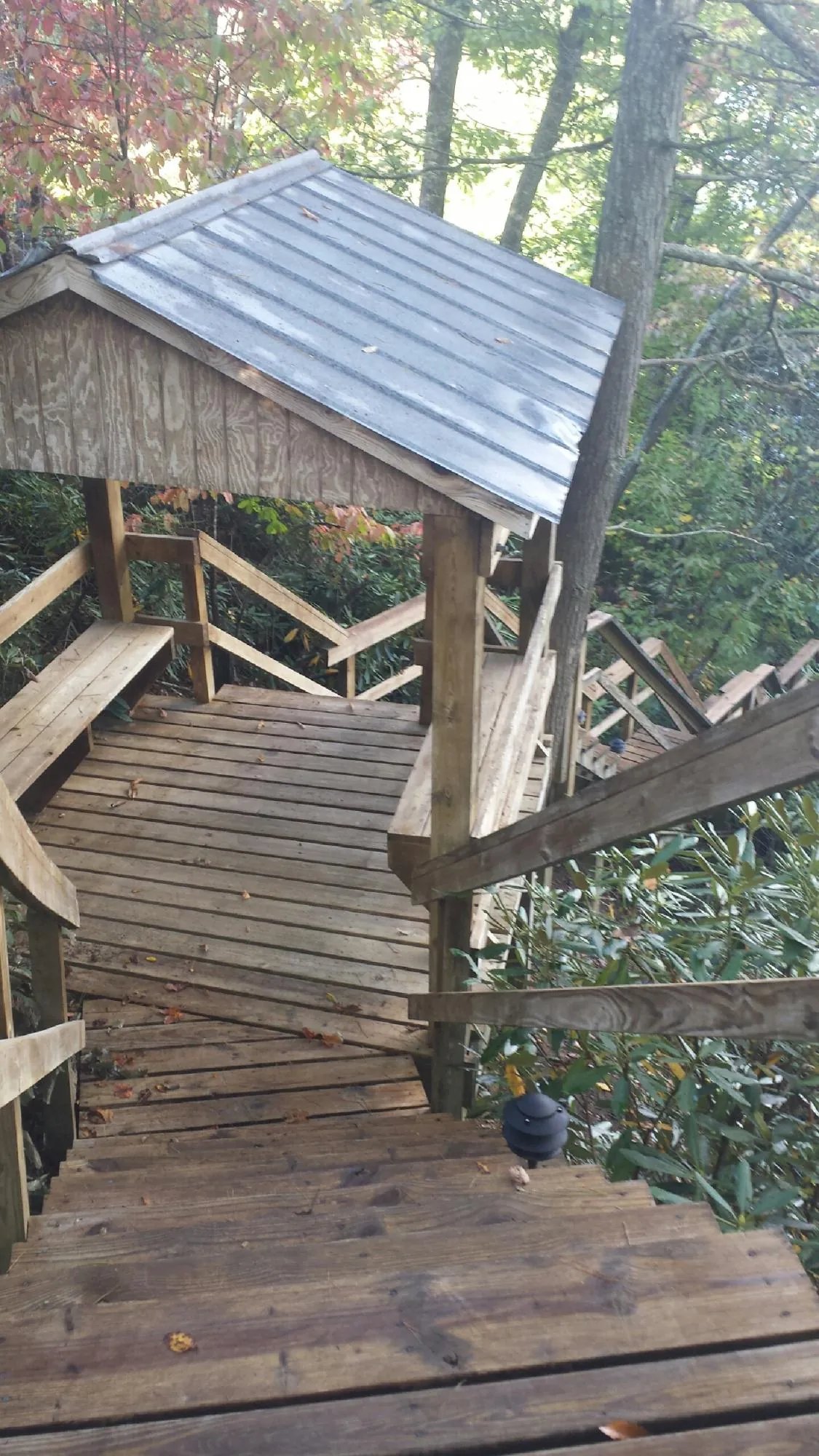 Metal roofed shelter over wooden steps on a wooded walkway — Skylight Repair & Installation work by our crew in Natural Bridge Station