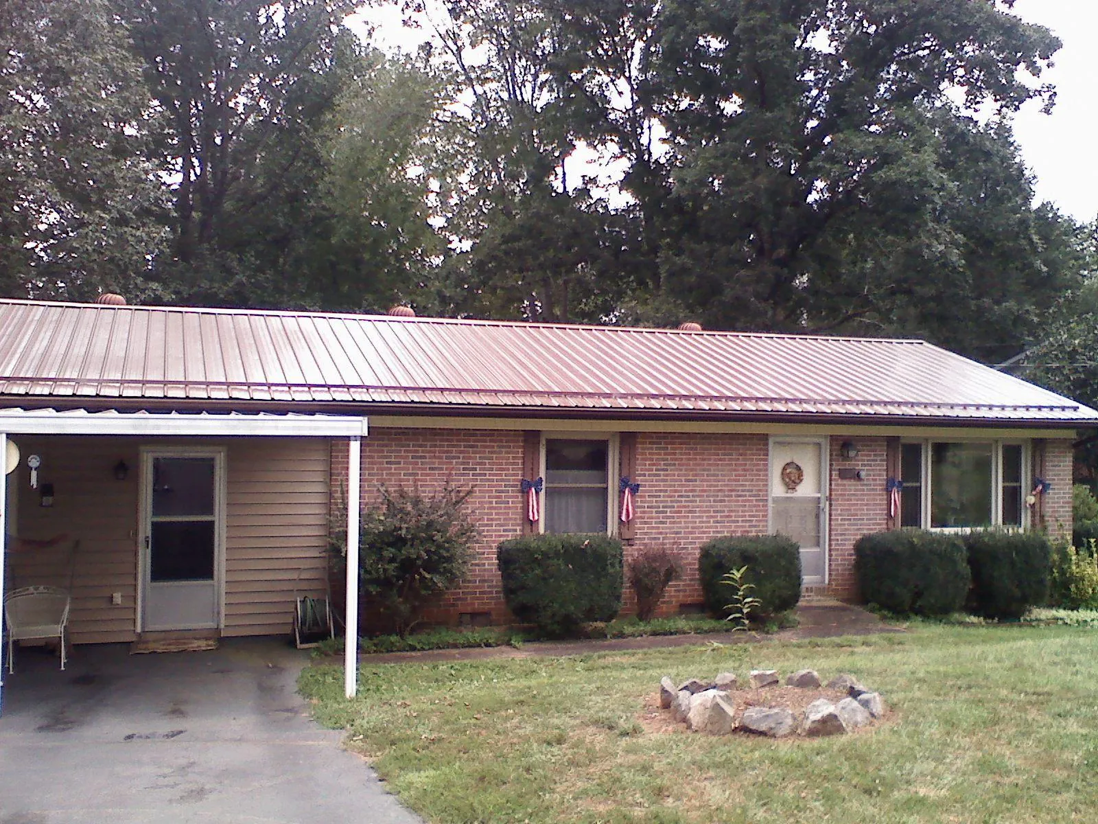 Bronze metal roof and carport on a brick ranch home — Roof Repair work by our crew in Natural Bridge Station